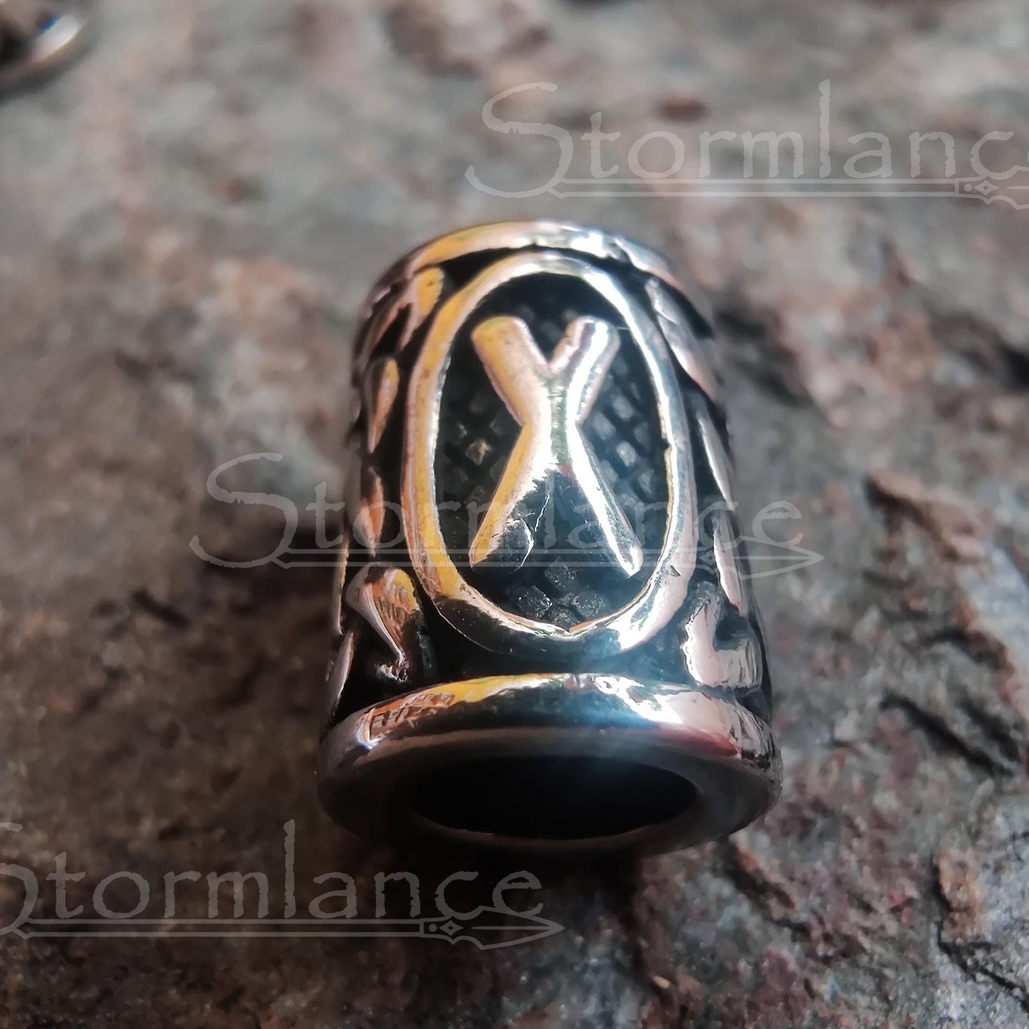 Viking hair and beard bead laying on a granite stone slab