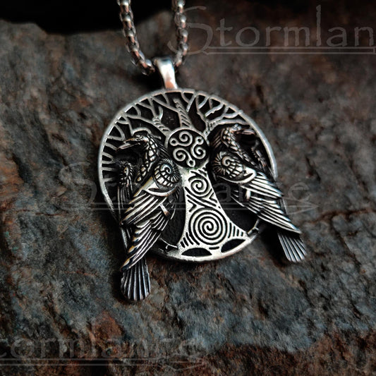 Yggdrasil (tree of life)pendant with huginn and muninn ravens  made of stainless steel, laying on a granite stone slab