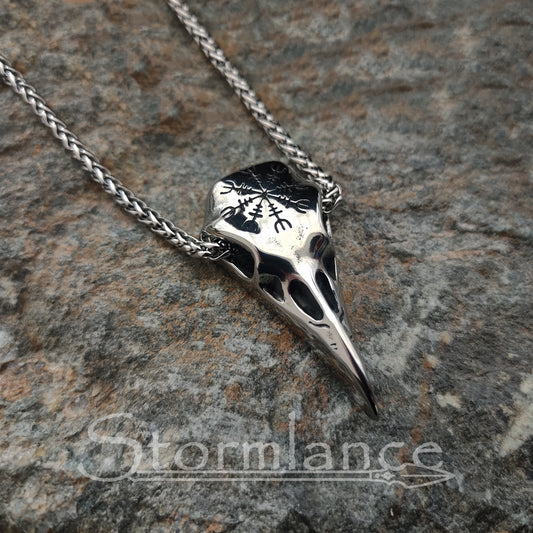 raven skull pendant with helm of awe made of stainless steel, laying on a granite stone slab