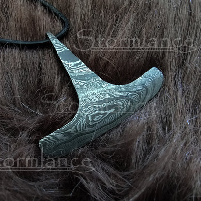 Big Thor's hammer (Mjolnir) pendant made of Damascus steel, laying on a piece of fur