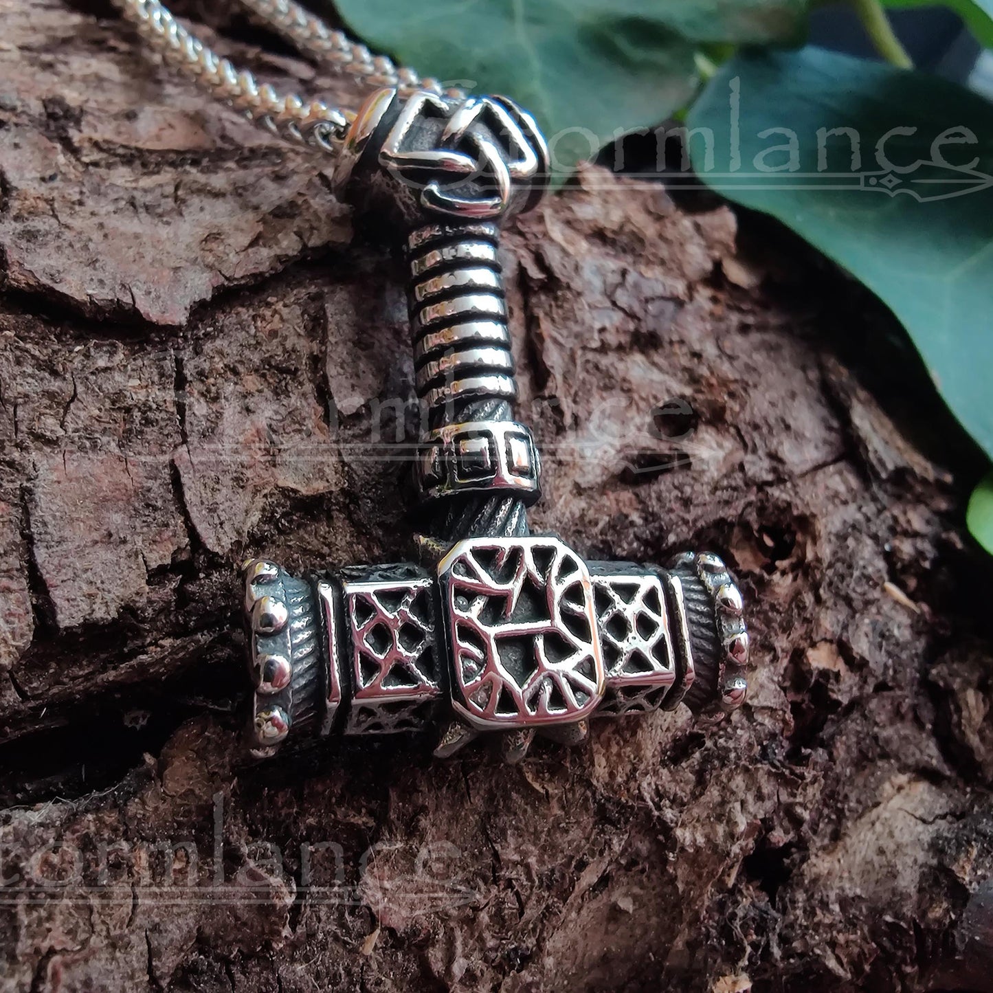 dwarf thor's hammer pendant made of stainless steel, laying on a granite stone slab