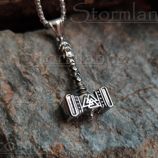Mjolnir valknut pendant made of stainless steel, laying on a granite stone slab