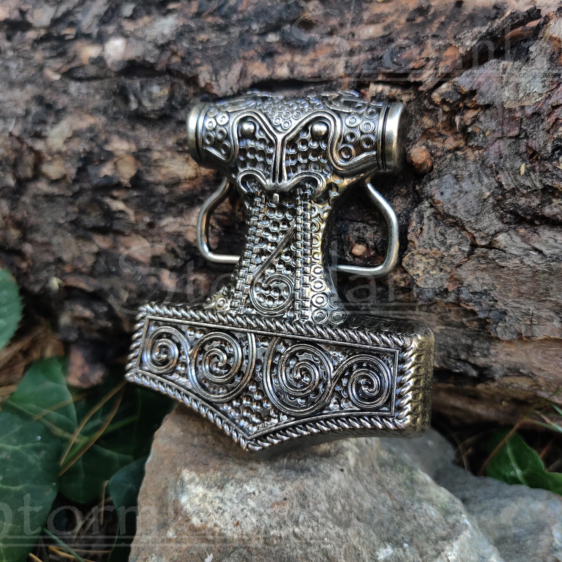 Viking Mjolnir Belt Buckle made of stainless steel, laying in a forest