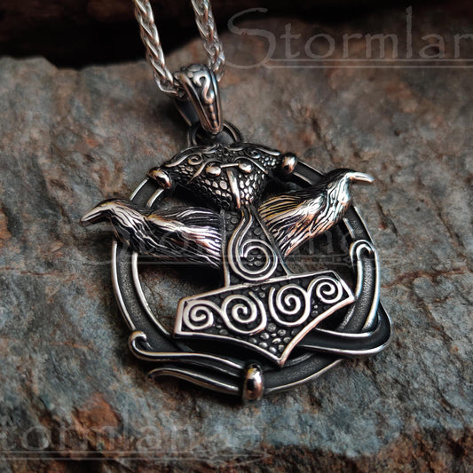 Mjolnir with huginn and muninn pendant made of stainless steel, laying on a granite stone slab