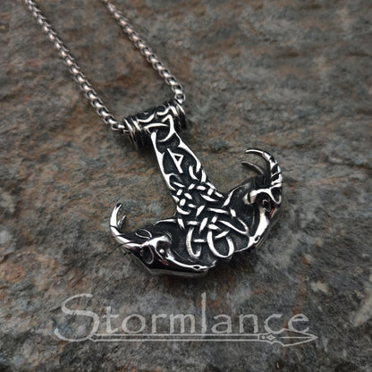 Mjolnir with Thor's goats pendant made of stainless steel, laying on a granite stone slab