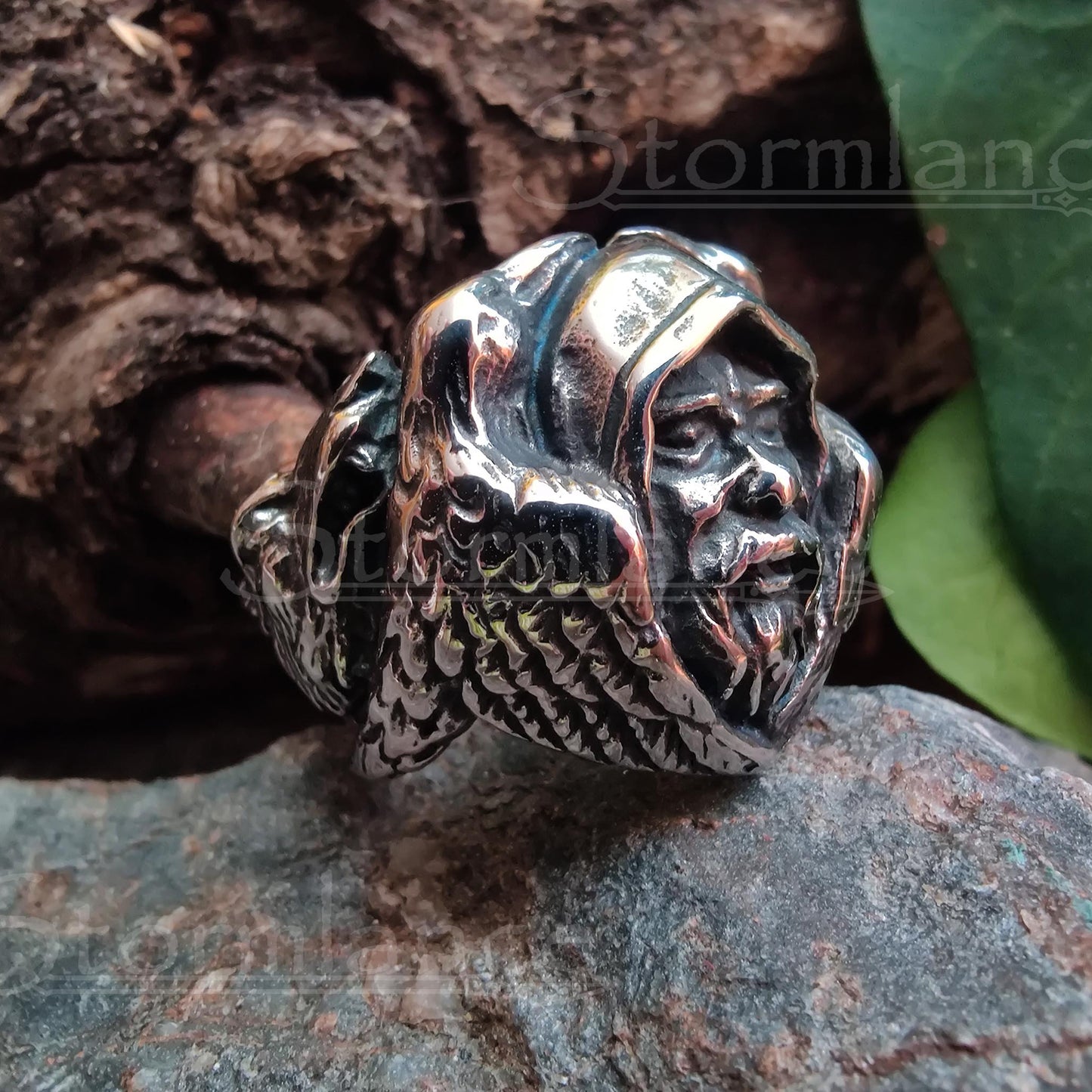 odin head with ravens ring made of stainless steel, laying on a granite stone slab