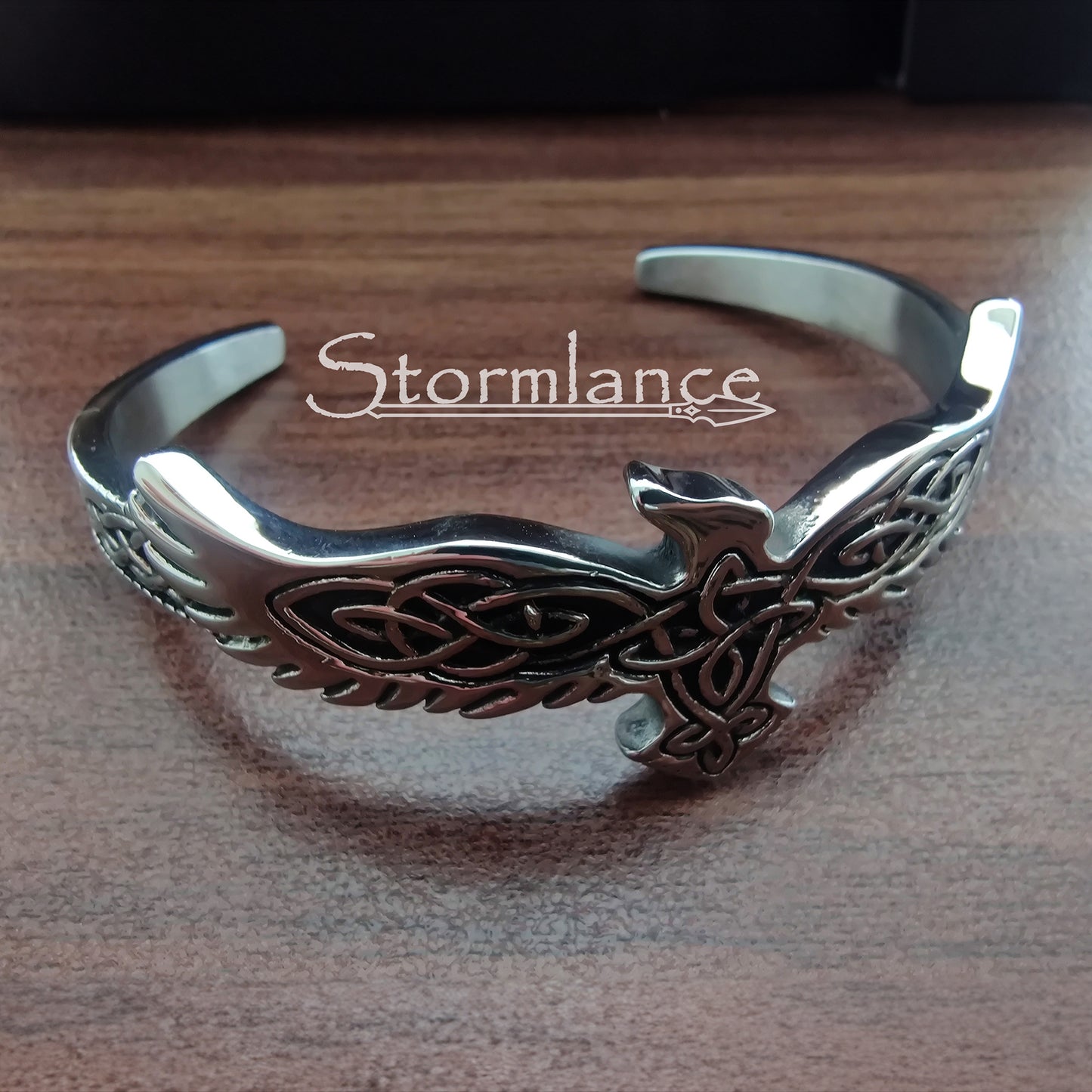 Raven Bracelet Made of Stainless Steel placed on a wooden desk