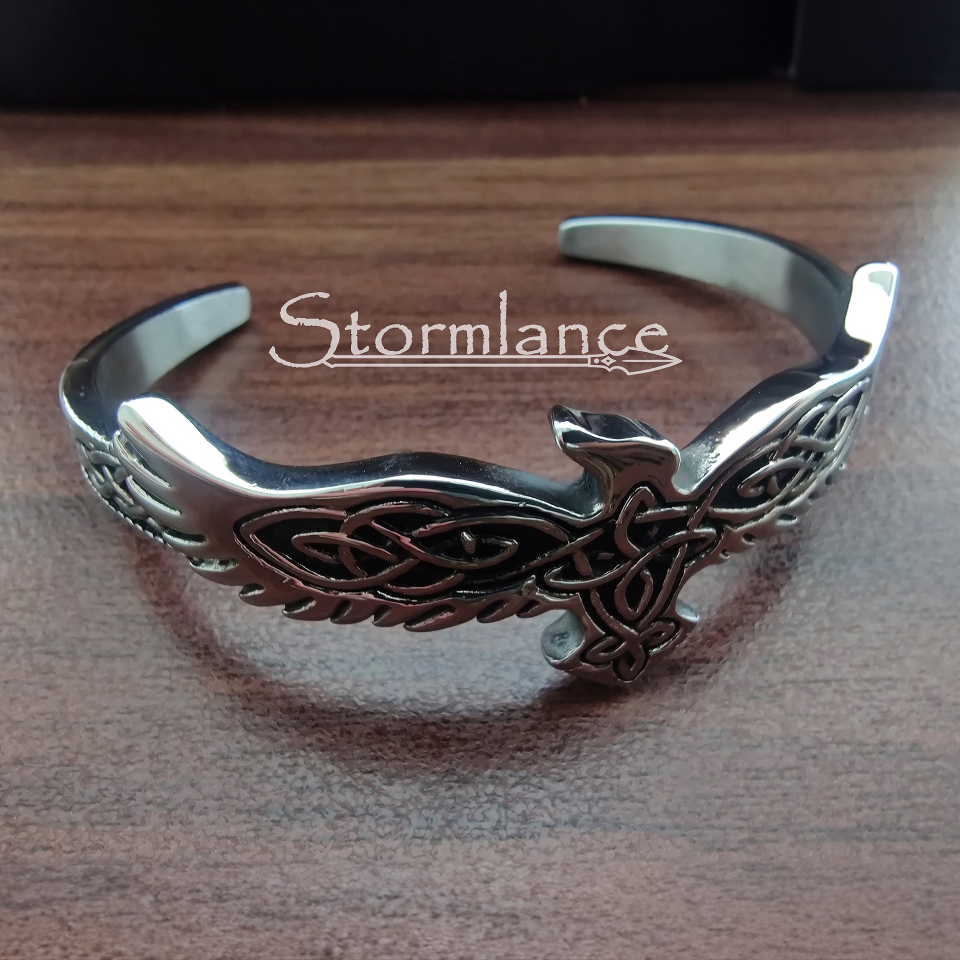 Raven Bracelet Made of Stainless Steel placed on a wooden desk