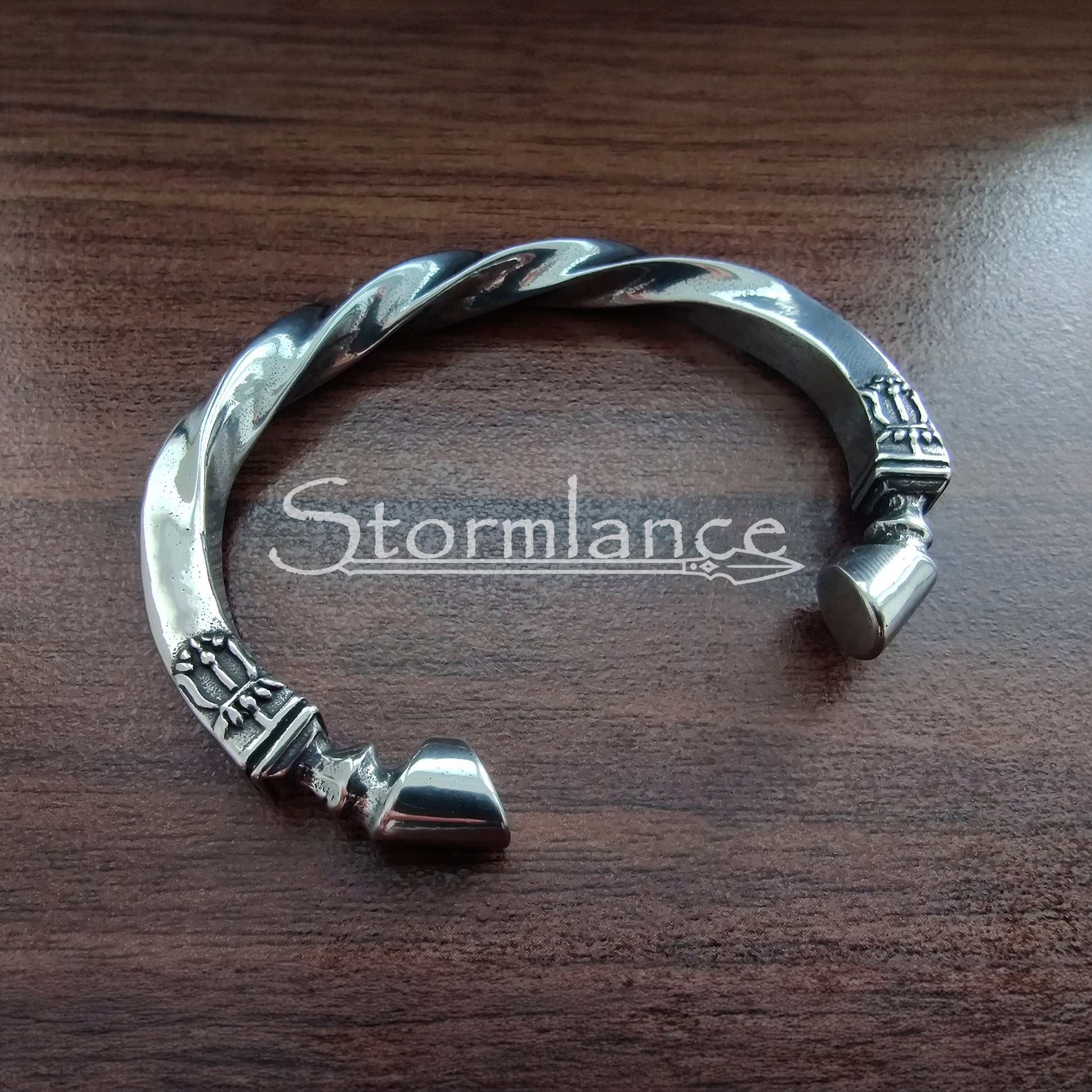 Sleipnir Horse Arm Ring made of Stainless Steel on a wooden background