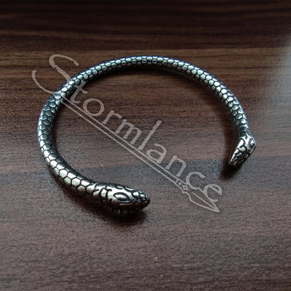 Snake Jormungandr Bracelet made of stainless steel laying on a wooden desk