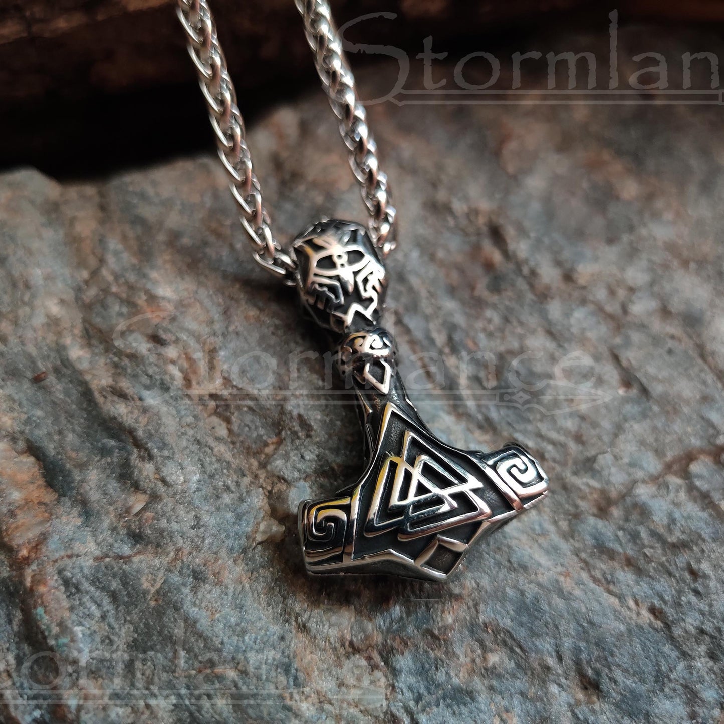 Valknut mjolnir pendant made of stainless steel, laying on a granite stone slab