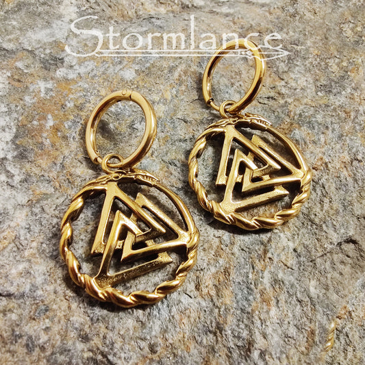 Valknut Earrings Gold in Color made of stainless steel laying on a stone slab