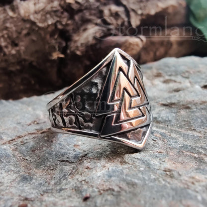 valknut ring made of stainless steel, laying on a granite stone slab