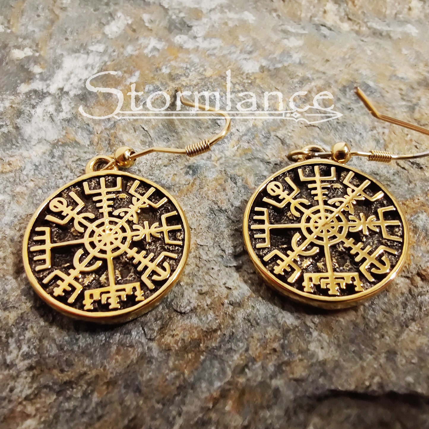 Vegvisir Earrings Gold in Color made of stainless steel laying on a stone slab
