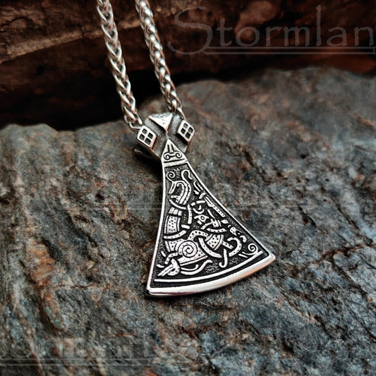 viking axe pendant made of stainless steel, laying on a granite stone slab