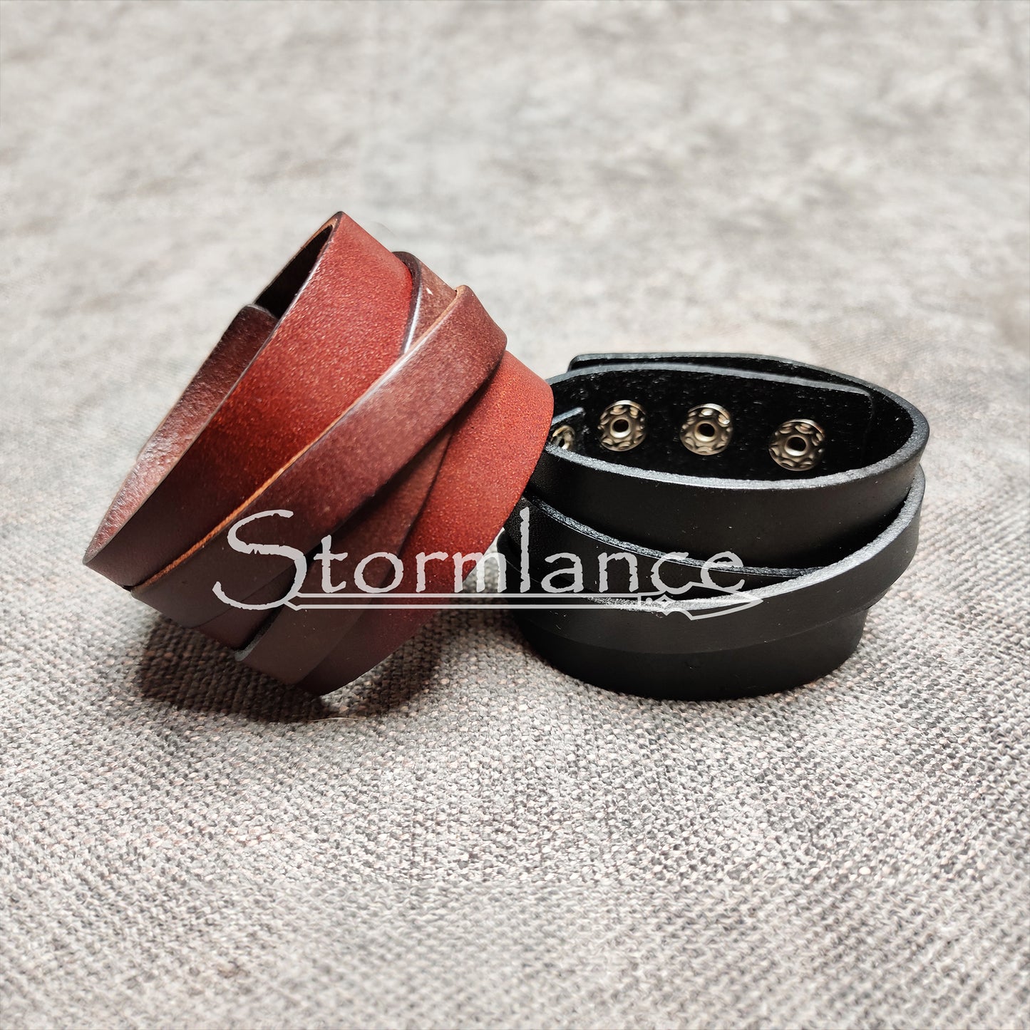 brown and black genuine leather bracelets laying on a cotton fabric