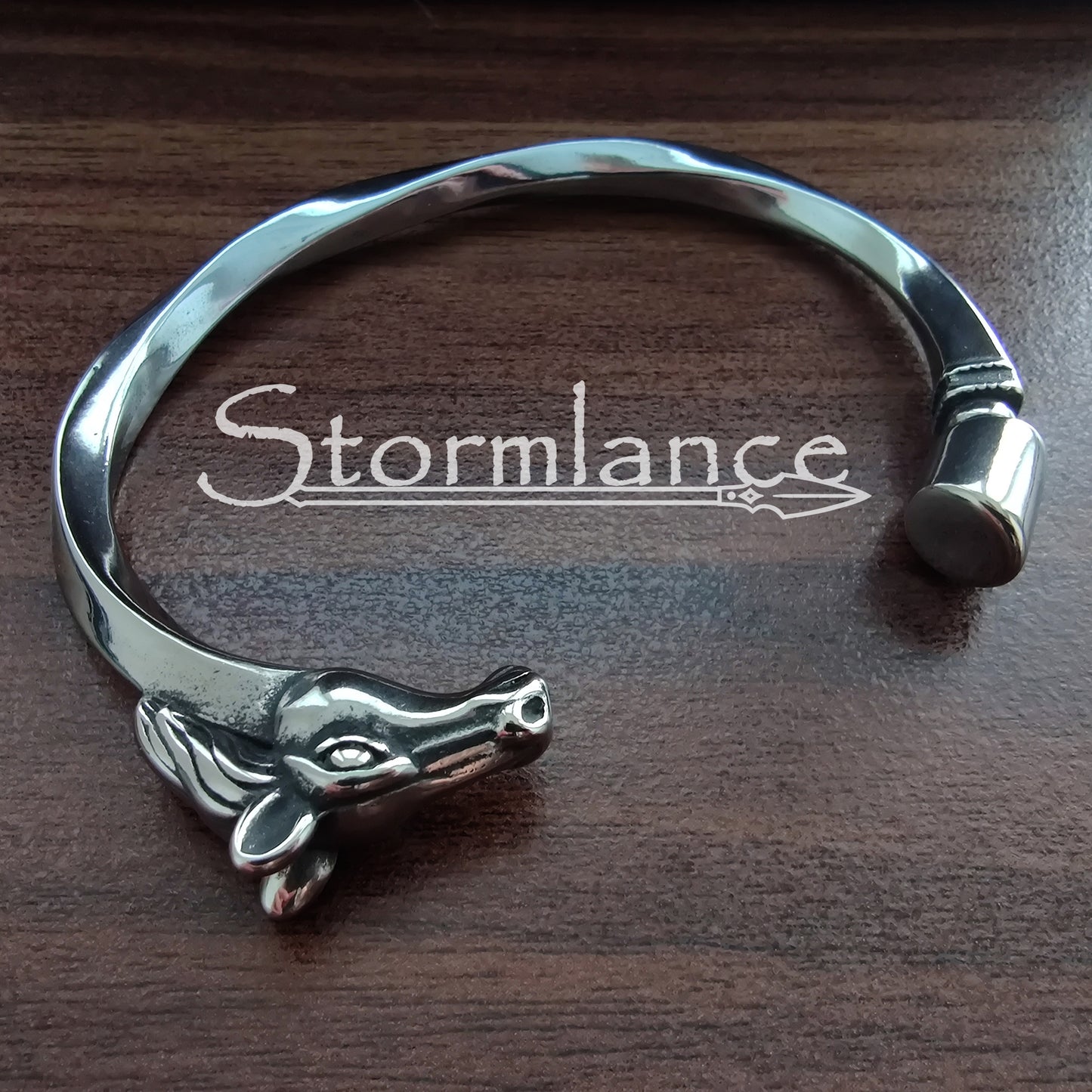 Sleipnir Warhorse Arm Ring made of Stainless Steel on a wooden background